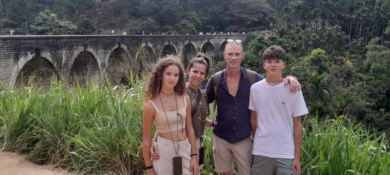 A family of four standing in front of the Nine Arches Bridge near Ella